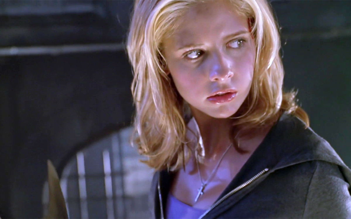 A shot of Buffy from the shoulders up, holding a weapon and looking triumphant.