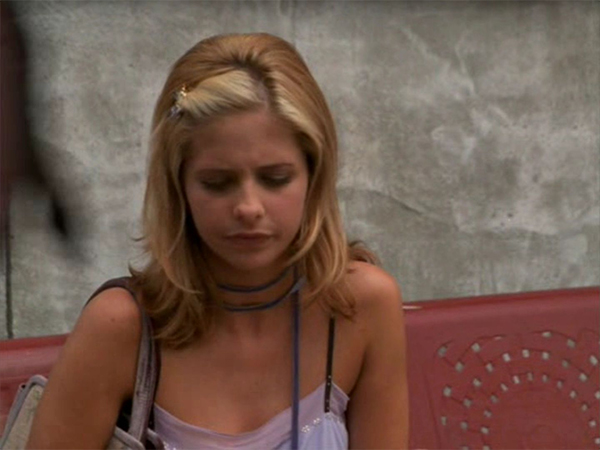 Buffy sits on a bench after Willow misses their meeting.