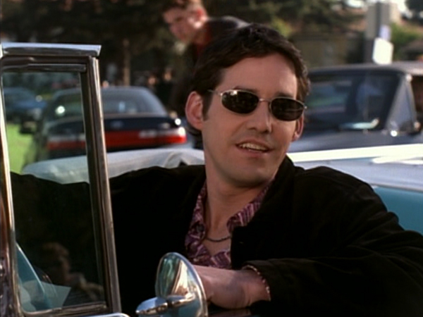 Xander leans out of a car wearing sunglasses.